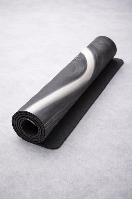 Rolling black yoga mat on a light gray background